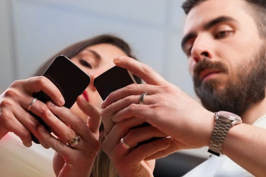From below, a man and woman are absorbed in their phones, despite closeness. Mobile apps and messaging systems highlight the constant presence of work and the dual edge of technology
