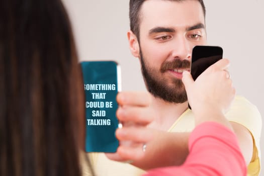 man and woman, instead of speaking, exchange screen views, preferring to show internet content, not using words. This modern scenario mirrors early humans showing items and nodding, sidestepping real