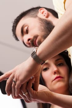 Man and woman close. He's on his phone, ignoring her signals of frustration. These devices, while undeniably useful, bring isolation and rudeness alongside boundless opportunities
