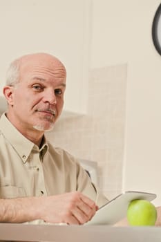 Looking directly at us with a mischievous and informed expression, an older individual holds a tablet, cleverly leaned on an apple. He's transitioned from paper to digital, but his thirst for worldly