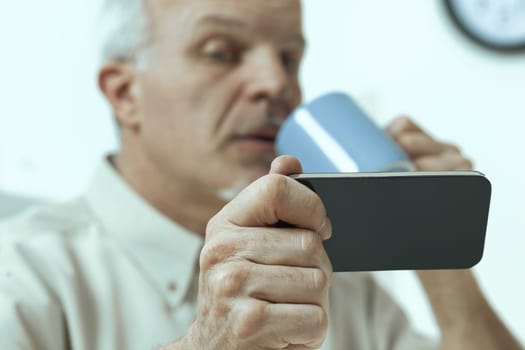 older gentleman, during meals and pauses, consults smartphone, tablet. His generation respects, not underestimates, technology. But discerning credible online information remains a shared difficulty