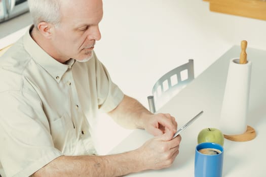 Senior individual connects to the digital realm with gratitude during mealtime breaks. While cherishing tech's wonders, he, like many, finds distinguishing between trustworthy and unreliable sources t