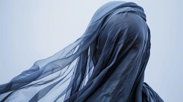 A woman stands with a veil covering her head. The veil is intricately designed and draped elegantly over her hair. She looks poised and regal.