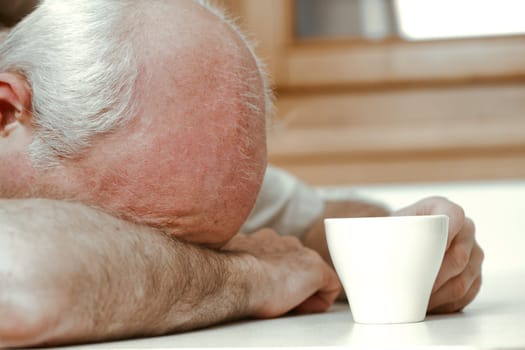 With dawn breaking, an old man grapples with fatigue, sipping his coffee. His daytime job is at risk due to sleeplessness. Earnings don't match the rising retirement age. Medical assistance is essenti