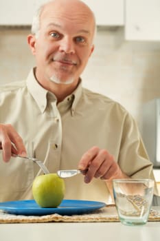 Elderly man, staring at a sole green apple, shows amusing reactions. Deep down, he detests his diet, yearning for flavorful, fatty, and sweet meals. But a stark medical caution stands: those choices s