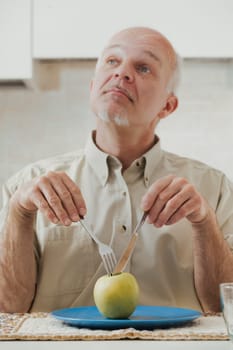 green apple sits before an old man who's poised to eat. Using utensils and making comical expressions, he secretly loathes his diet, longing for tasty, high-fat, and sugary foods. Yet, the medical war