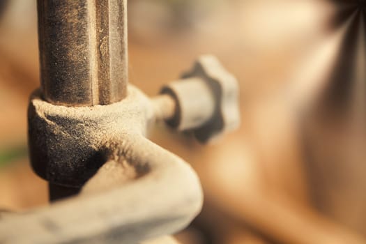 Small detail in focus of an adjustment, knob or in an element of woodworking tools, while the rest remains out of focus. Atmosphere and light in a craftsman carpenter's workshop. Wood and metal.