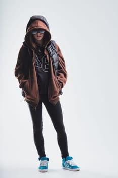 young woman is dressed in an urban casual fashion, highlighting brown and blue hues