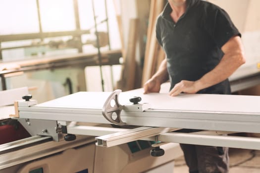 Craftsman at work in his own workshop. One man works with proper tools, shelves to saw, sand, plane, and finish wooden parts and surfaces.