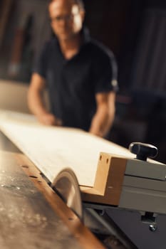 A man works with a circular saw. He could be a carpenter or a worker in a sawmill, but the skills of manual labor must be accompanied by knowledge of machines in today's world, and he knows this