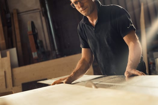 A man works with a circular saw. He could be a carpenter or a worker in a sawmill, but the skills of manual labor must be accompanied by knowledge of machines in today's world, and he knows this