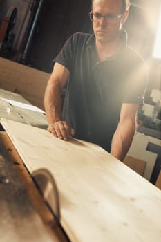 A man works with a circular saw. He could be a carpenter or a worker in a sawmill, but the skills of manual labor must be accompanied by knowledge of machines in today's world, and he knows this