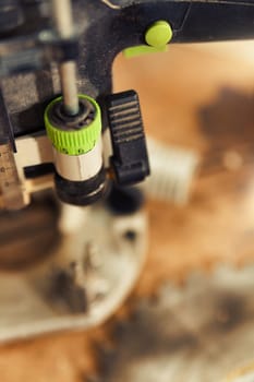 Small detail in focus of an adjustment, knob or in an element of woodworking tools, while the rest remains out of focus. Atmosphere and light in a craftsman carpenter's workshop. Wood and metal.