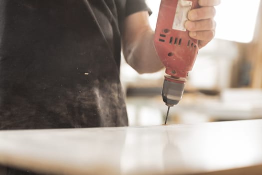 Detail in focus: a beautiful red drill is a faithful tool and companion of the woodworker. In his craft store he finds it reliable and uses it skillfully.