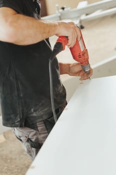 Detail in focus: a beautiful red drill is a faithful tool and companion of the woodworker. In his craft store he finds it reliable and uses it skillfully.