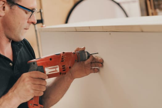 Detail in focus: a beautiful red drill is a faithful tool and companion of the woodworker. In his craft store he finds it reliable and uses it skillfully.