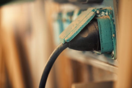 Small detail in focus of an adjustment, knob or in an element of woodworking tools, while the rest remains out of focus. Atmosphere and light in a craftsman carpenter's workshop. Wood and metal.