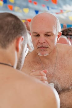 Strategic strength at play as a senior competes in indoor arm wrestling bout