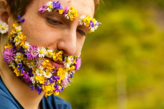 Within nature's fold, a man's distinct appearance emerges: a face covered in blossoms. His bond, whether perceived or real, with the environment is deep and unwavering