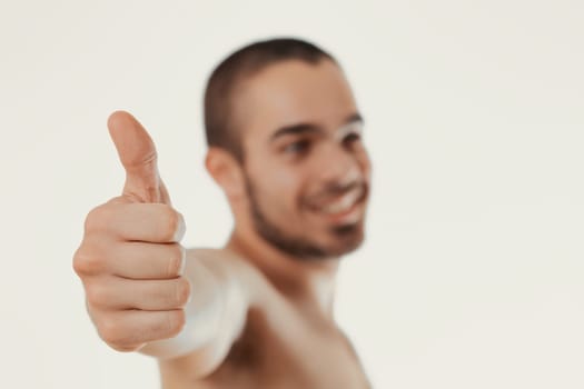Smiling man with a thumbs-up signals accomplishment