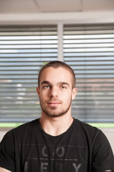 Serene expression defines the young adult against a soft-lit background, mugshot
