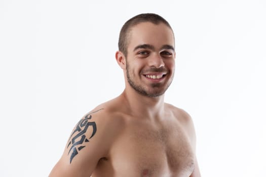 Young man with a warm smile, showcasing his tattoo on a bare torso