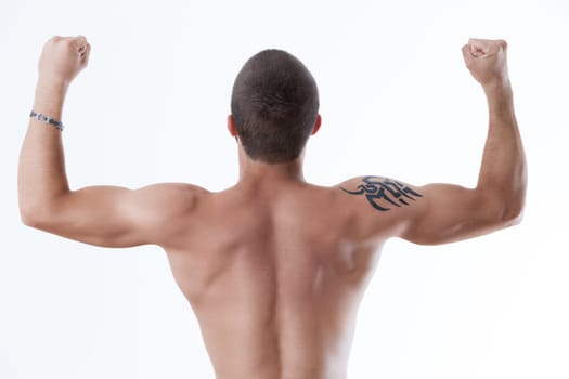 Athletic physique from behind, arms up in triumph, tattoo accentuated