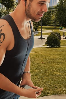 Active man in tank top enjoys music, resting from workout