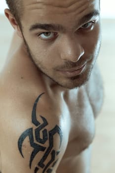 Focused young individual with intricate shoulder tattoo