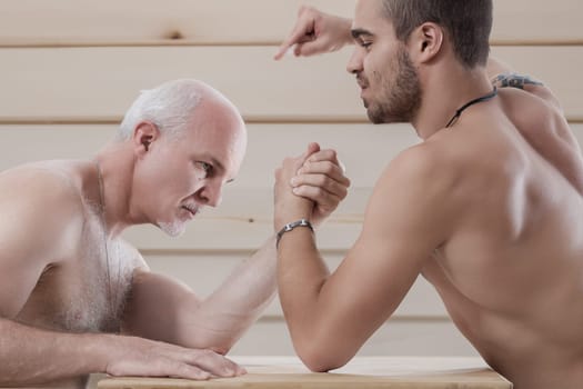 Young wins old. Strategic contest of arm strength, elder versus young in a playful match