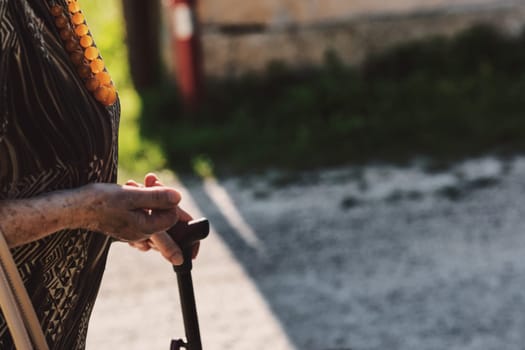 Her blemished hand on the stick epitomizes survival with purpose. Walking in the open air serves as her remedy for better circulation and overall well-being