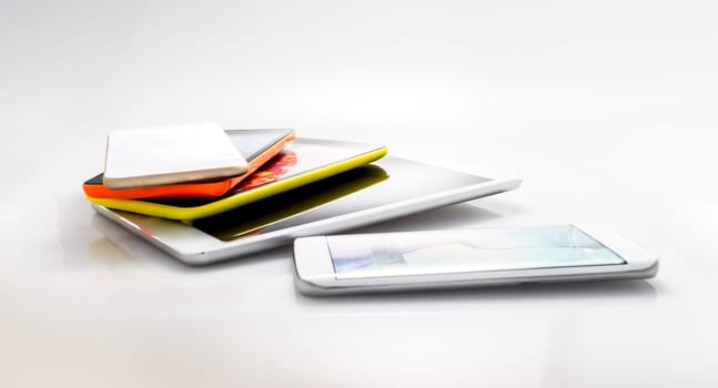 Group of smartphones, cell phones, digital tablets and mobile technology devices, grouped together but isolated on a white or shaded background.
