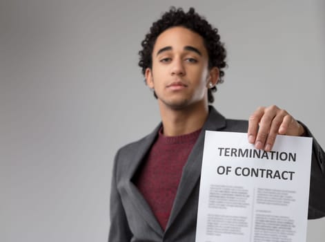 Poised and with determination, he showcases a 'TERMINATION OF CONTRACT' notice to emphasize its gravity