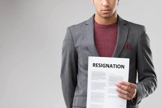 Conveying a significant moment, the man's serious face accentuates the importance of the 'RESIGNATION' letter he holds