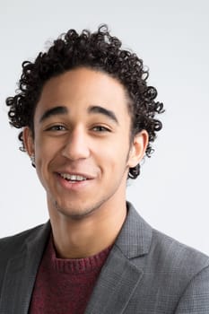 With expressive eyes and curly locks, the man's attire suggests a balance of casual and formal
