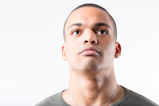 Young, short-haired black man in military stance. Either awaiting orders or just looking up, he stands rigidly and austere, strong and muscular