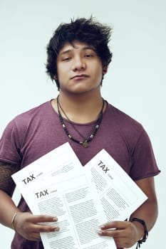 With tax documents in hand, young bored man sports a unique necklace, a clear tattoo, and a maroon top. Their black hair adds a distinctive touch