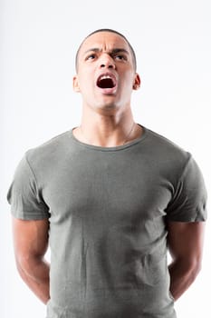 A man in military-style pose, shouting assertively. His high chin, puffed chest, broad shoulders, shaved head, and his military green shirt are isolated from the background