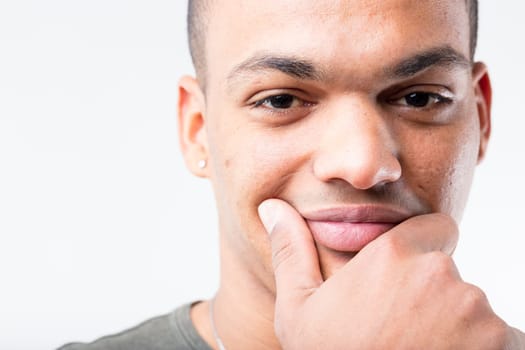 Extreme close-up portrait of black man, who's deep in thought. He's either on the cusp of a brilliant, money-making idea or suspicious of being deceived