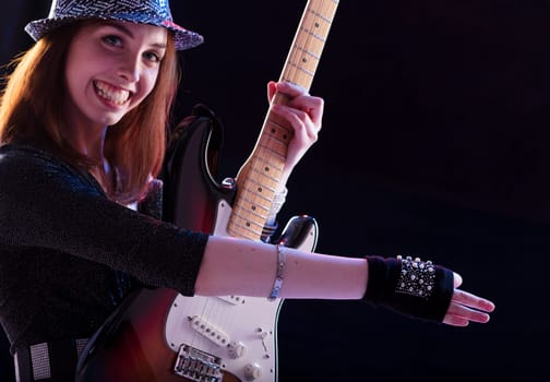 Strumming her guitar, the joyful artist combines her passion for music with a keen sense of style