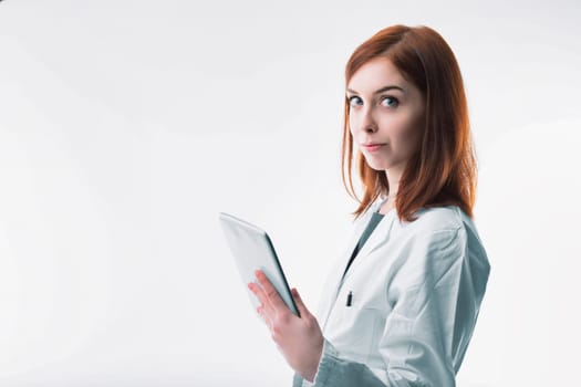 healthcare professional with auburn hair confidently holds a tablet, symbolizing the integration of technology in medicine
