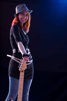 The electric guitarist, adorned in a sparkling garment, radiates happiness with each note played