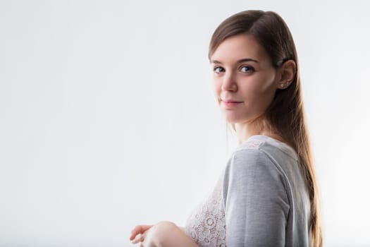 Contemplative young woman in a lace-adorned shirt, offering a glimpse of calm assurance