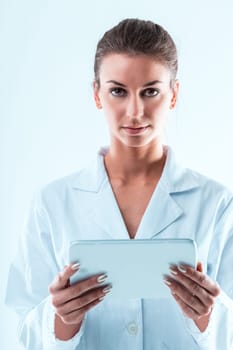 A woman in a white coat holding a white digital tablet. A STEM expert, discerning in data analysis and scientific research, she verifies thoroughly, steering clear of predatory journals