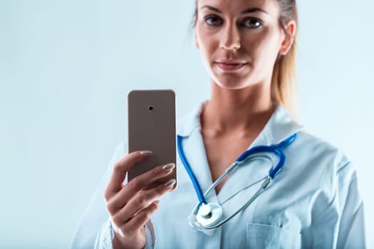 Smartphone held by a manicured hand of a doctor, suggesting online work via mobile. Benefits are plentiful with less commuting, if you can adapt to the change. You decide