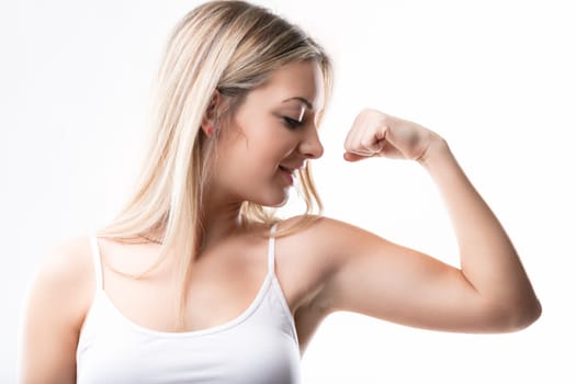 Fitness advocate in a casual tank top celebrates her muscular achievement