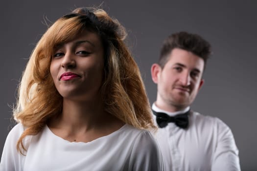 Confident woman in the foreground with a man slightly blurred behind