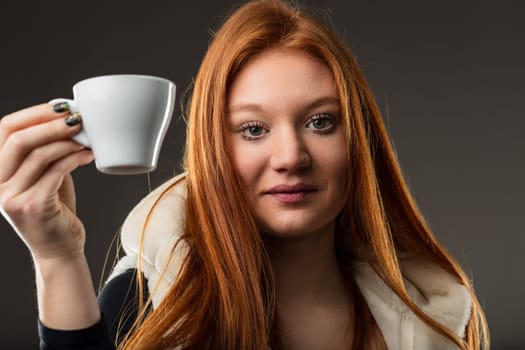 warm allure of a redhead holding her coffee, eyes gleaming with stories