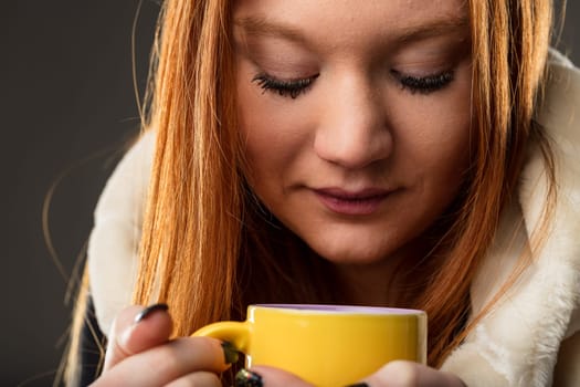 The warmth of the mug is mirrored in the woman's gaze, suggesting reflection and comfort