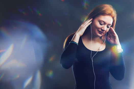young woman loses herself in the immersive world of music, surrounded by a prism of light reflections